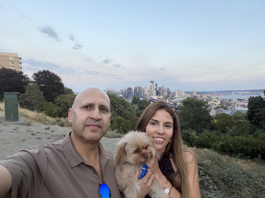 Fabian with companions and a small dog against the Seattle skyline at dusk.